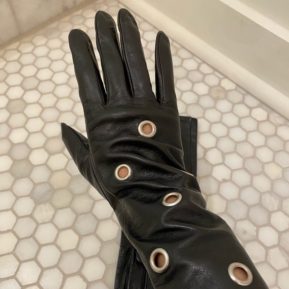 Women’s black leather gloves grommet hole design.